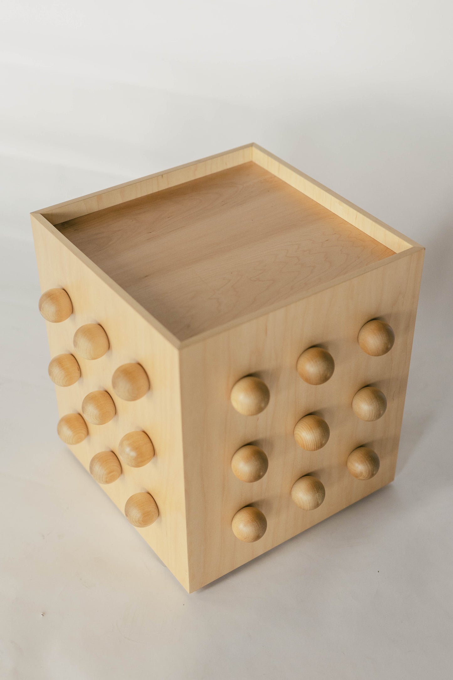 Wooden sculptural accent table on a light gray background