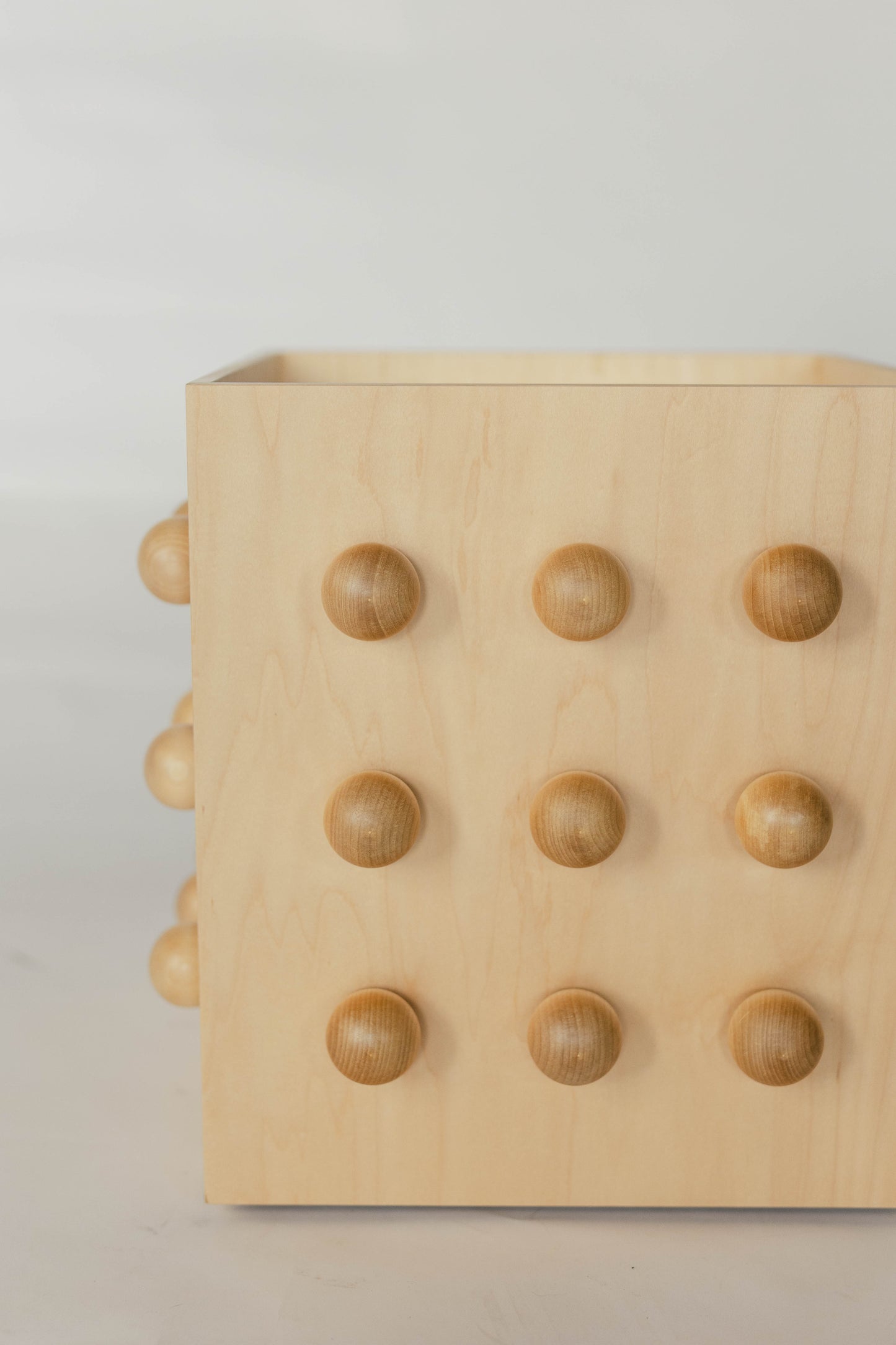 Wooden sculptural accent table on a light gray background