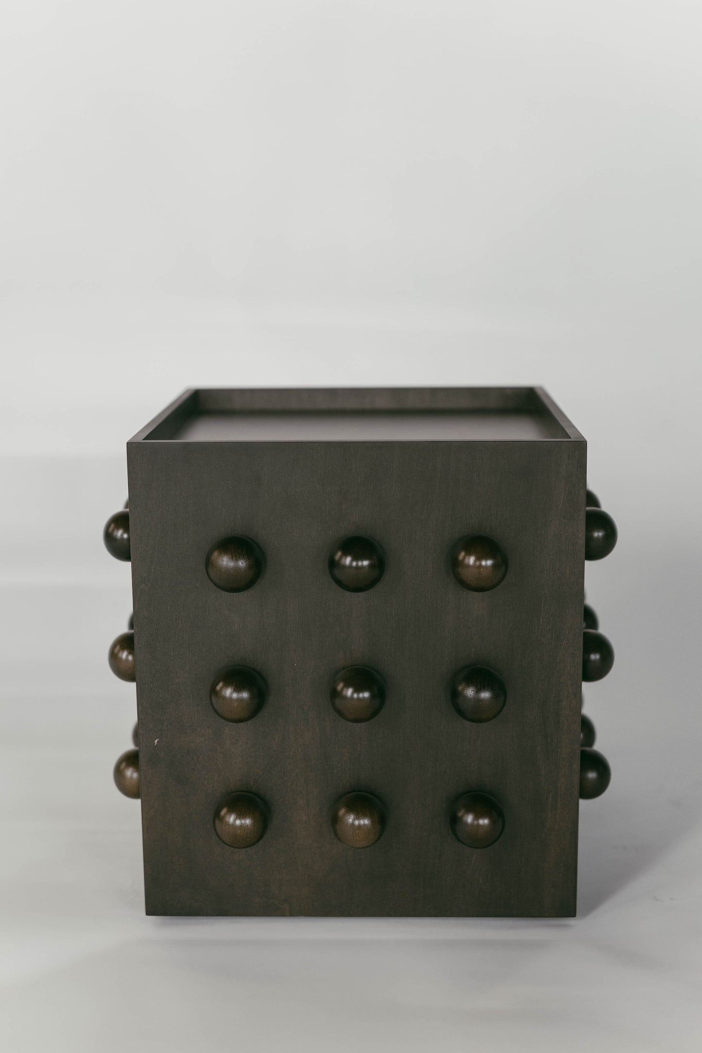 Wooden sculptural accent table on a light gray background