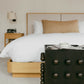 Bedroom with a bed, nightstand, and decorative box in a neutral setting