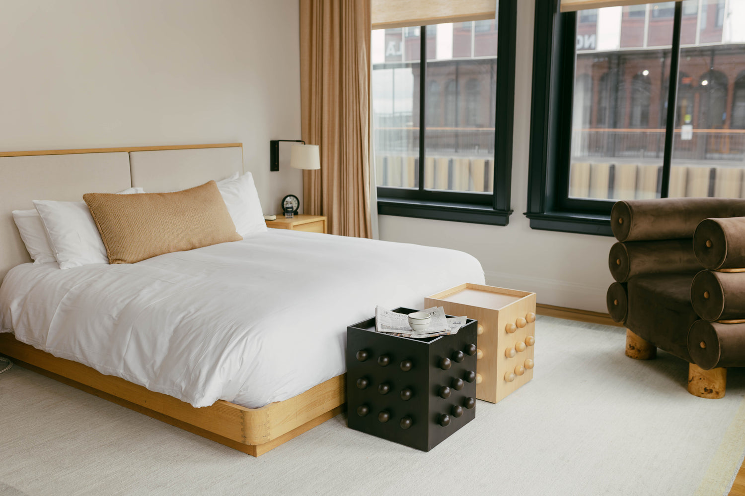 Modern bedroom with a bed, nightstands, and a chair.