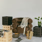 Contract Grade, Heirloom Quality furniture. Large velvet arm chair. Accent tables with 3 rows of 3 spheres styled in a studio with accessories like trench coat buckeled tall boots, vase with flowers.