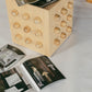 Wooden sculptural accent table with open magazines on a white surface