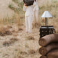 Person holding a large brown accent tables in a desert-like setting with various props around.