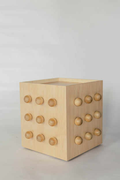 Wooden sculptural accent table on a light gray background