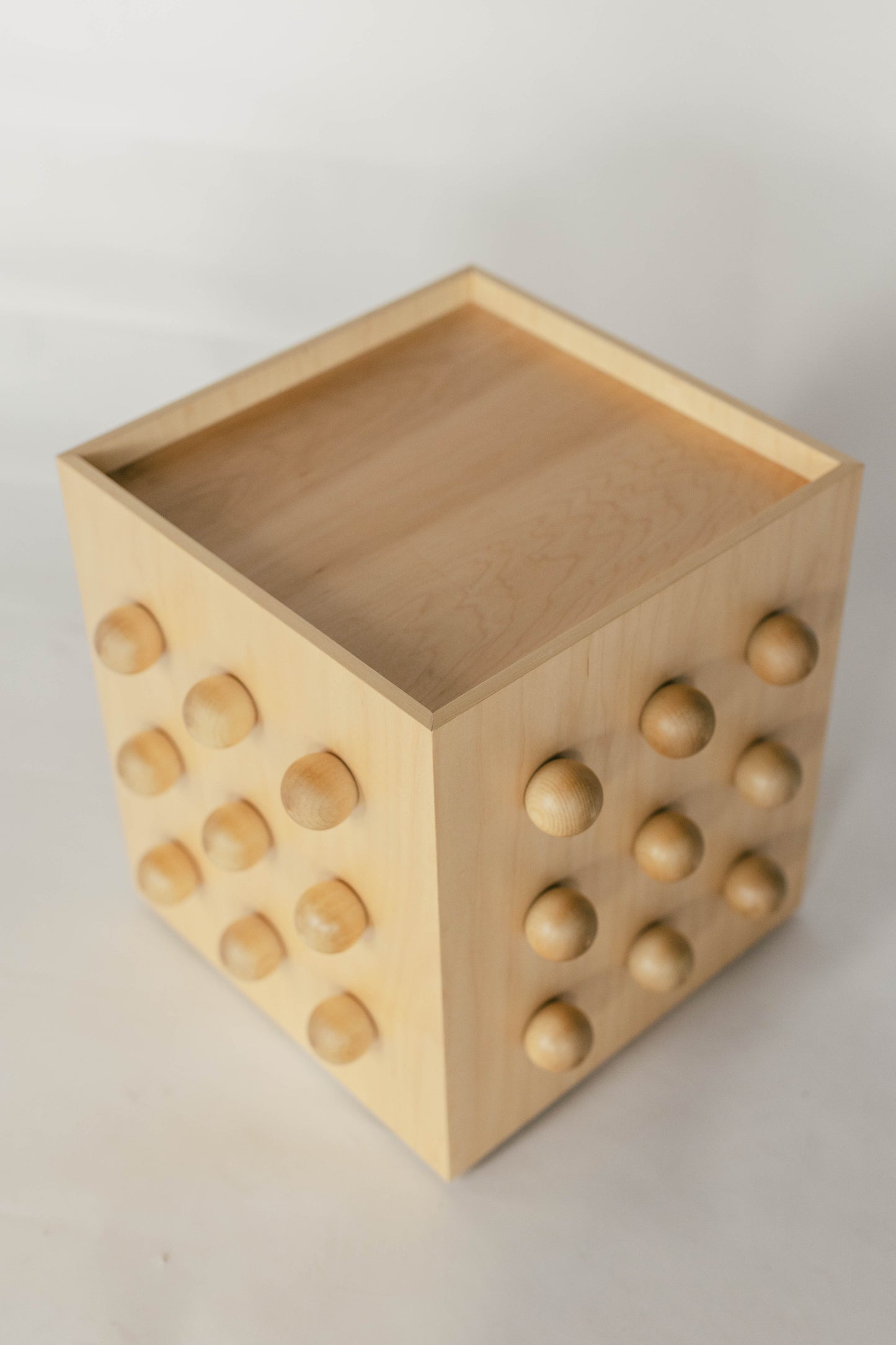 Wooden sculptural accent table on a light gray background