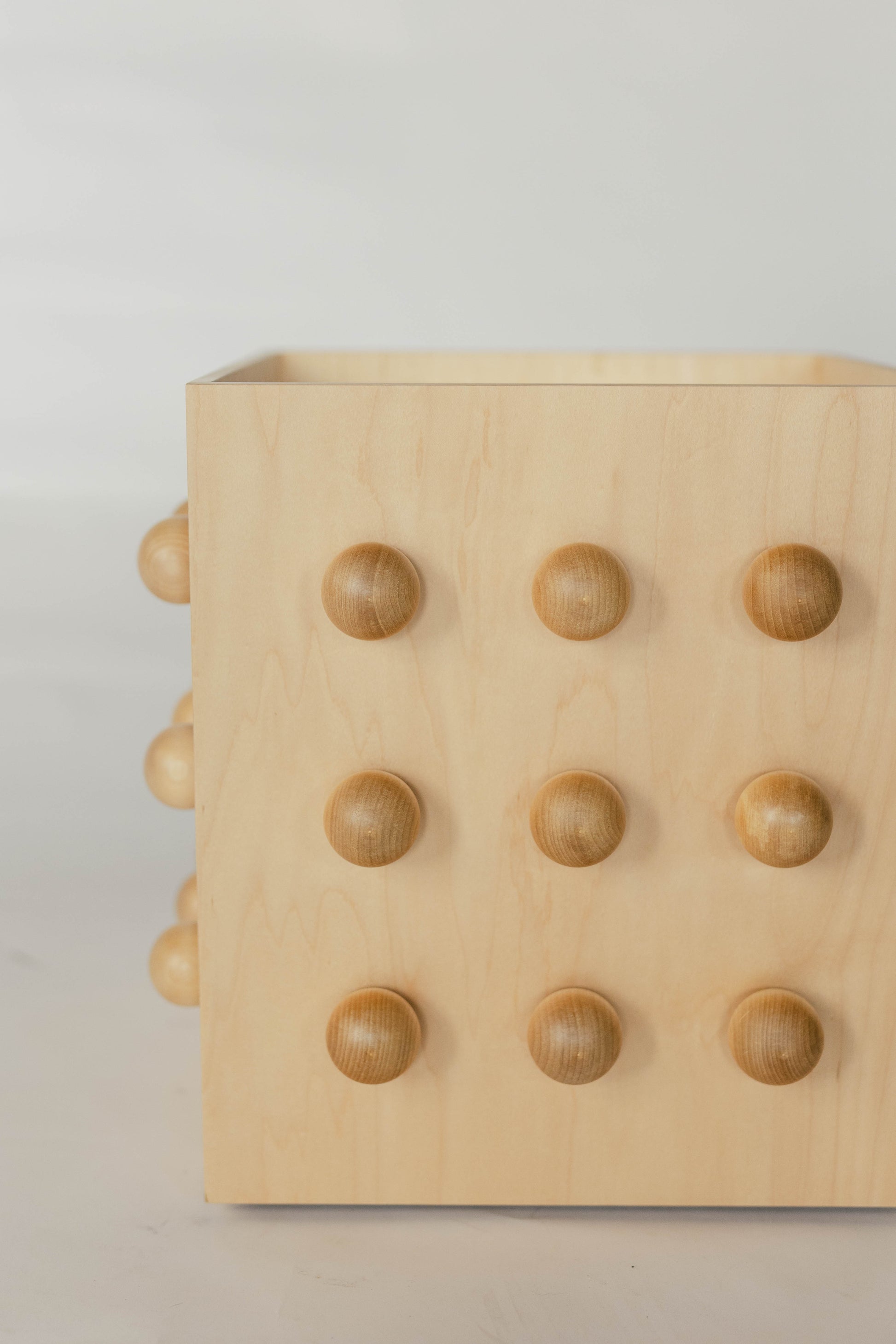 Wooden sculptural accent table on a light gray background